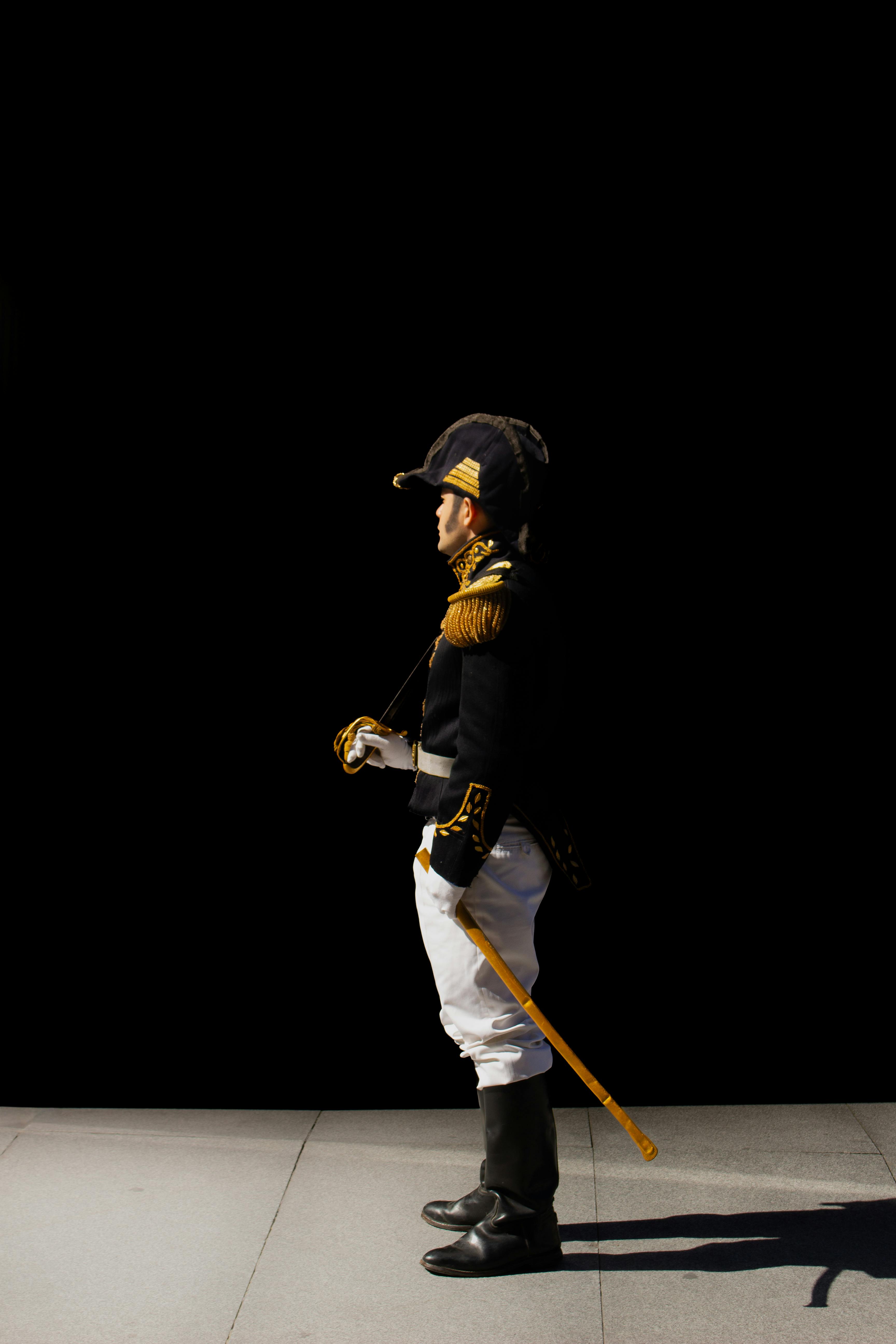 Gratuit Profilul unui soldat în uniformă istorică, stând pe un fundal negru solid. Fotografie de stoc