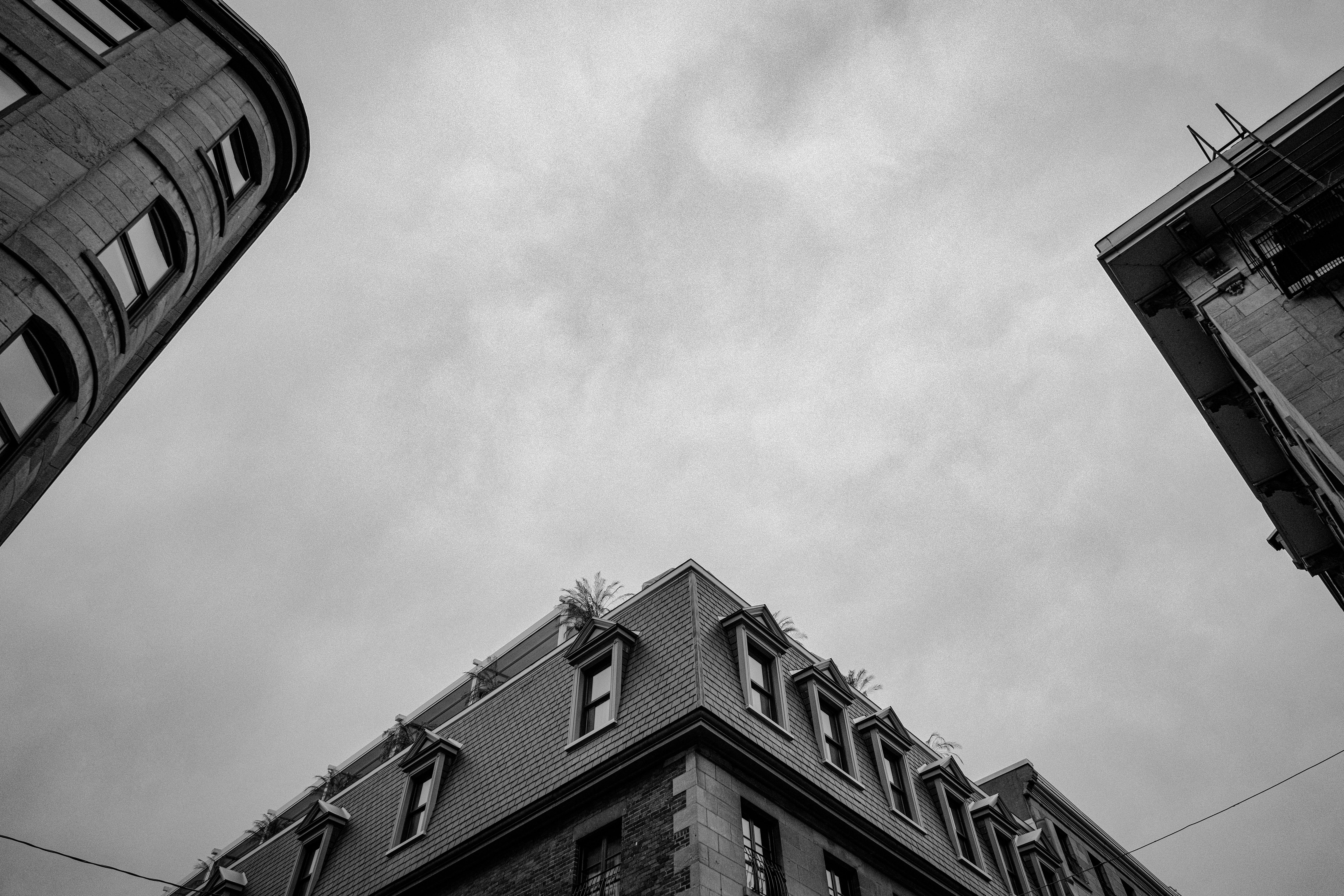 grátis Vista de ângulo baixo de diversos estilos arquitetônicos na Velha Montreal contra um céu cinza. Foto profissional
