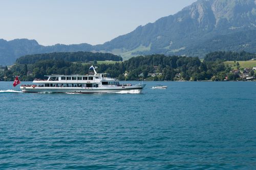 Free Passenger ferry cruising on Lake Lucerne with stunning Swiss Alps backdrop. Stock Photo