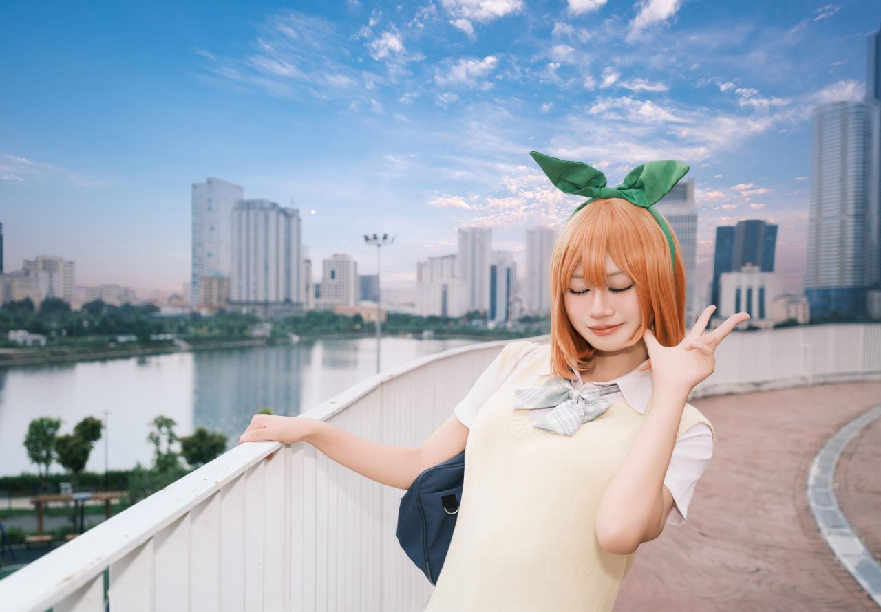 playful young woman poses joyfully on a bridge with a cityscape backdr