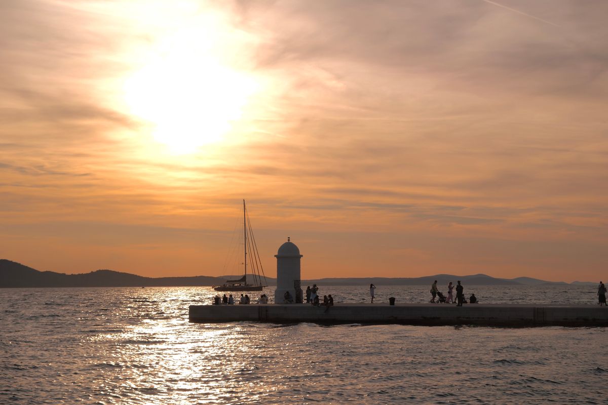 Zadar - apus peste Marea Adriatică cu oameni pe promenadă