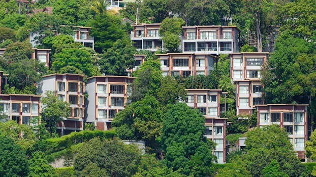 Tropical villas nestled on a lush hillside in Phuket, Thailand, showcasing vibrant greenery.