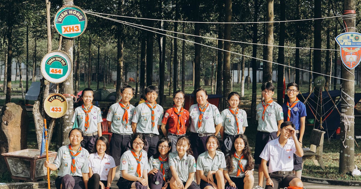 A group of scouts posing together in an outdoor forest setting, wearing uniform and smiles.