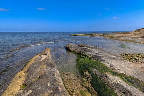 Free Beautiful rocky shoreline along Alicante's coast under a clear blue sky. Stock Photo