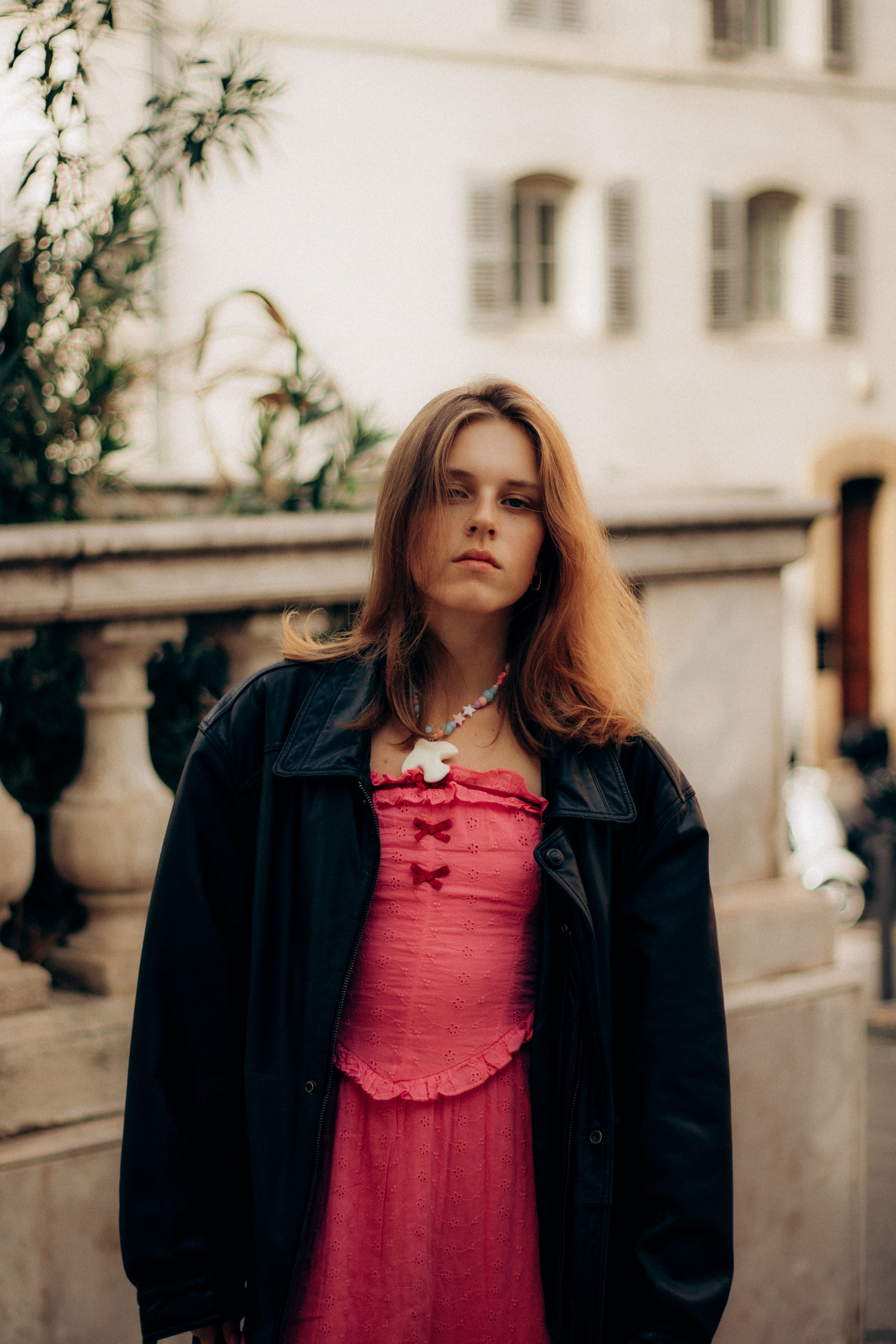 Stylish woman in pink dress posing outdoors in Marseille, France.