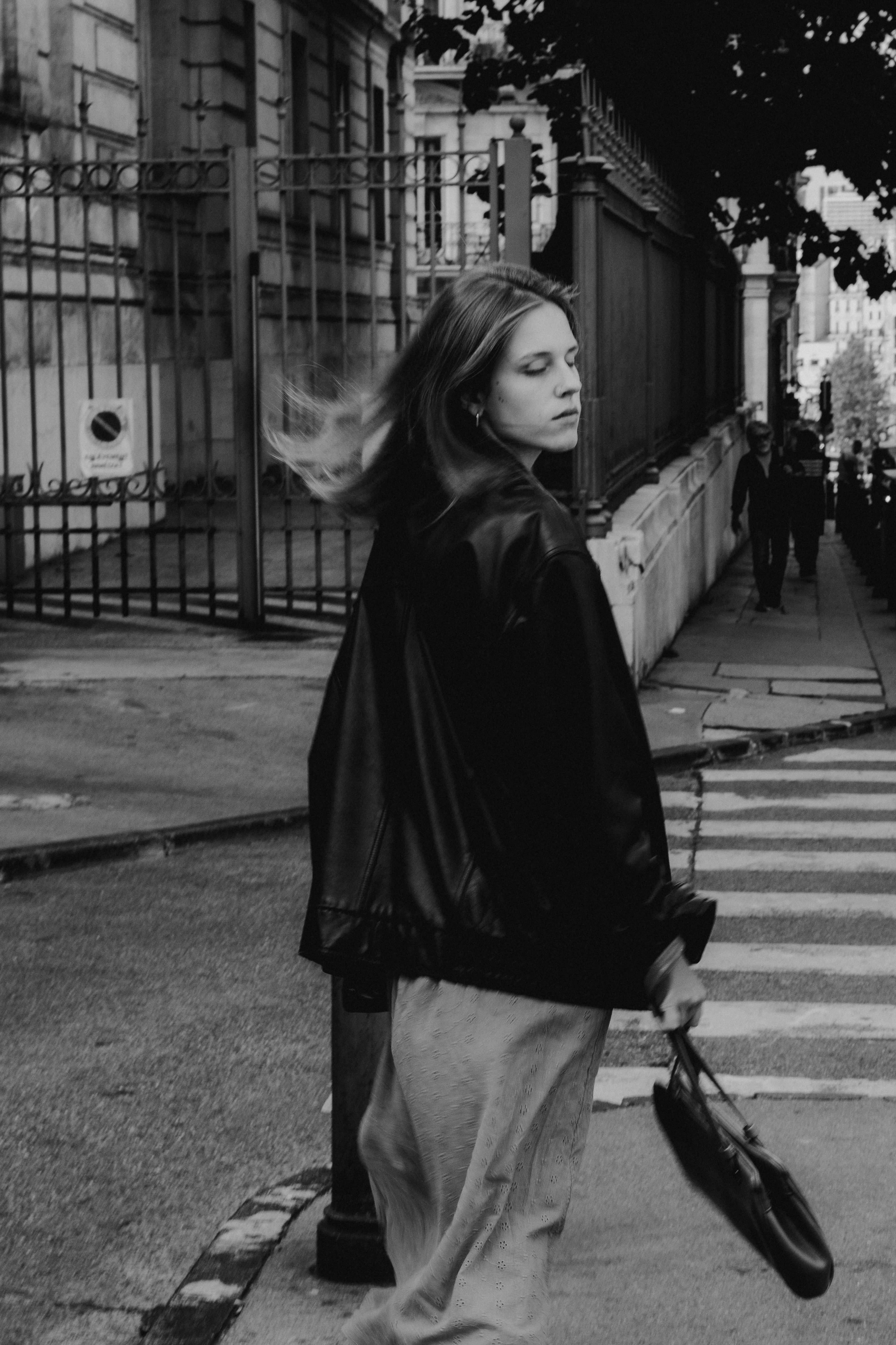 A fashionable woman strolls through a Marseille street in black and white.