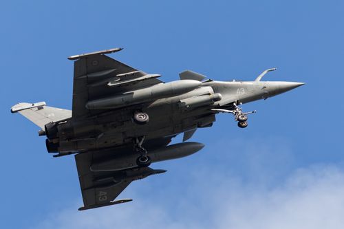 Free French Rafale fighter jet flying over Bretagne, France with landing gear deployed. Stock Photo