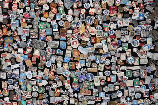 A dense collection of small metal badges — photo by Tahir Xəlfəquliyev on Pexels