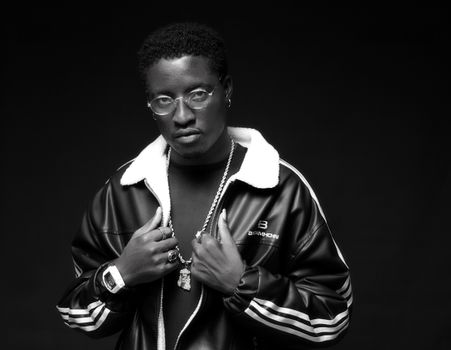 Black and white portrait of a man in trendy leather jacket with accessories.