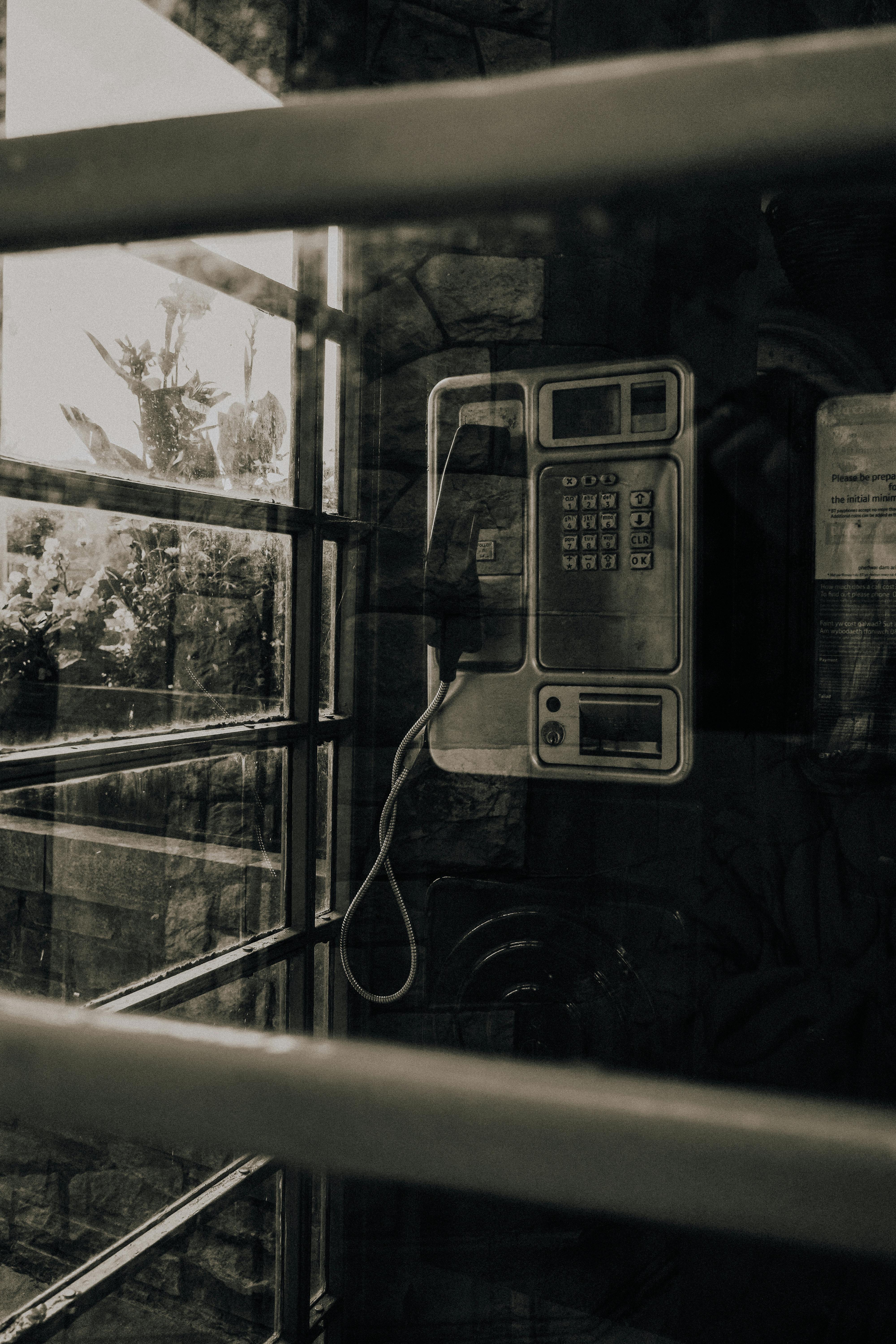 Kostenlos Retro-Telefonzellen-Interieur mit einem altmodischen Münztelefon, in Sepia-Farben für ein nostalgisches Gefühl. Stock-Foto