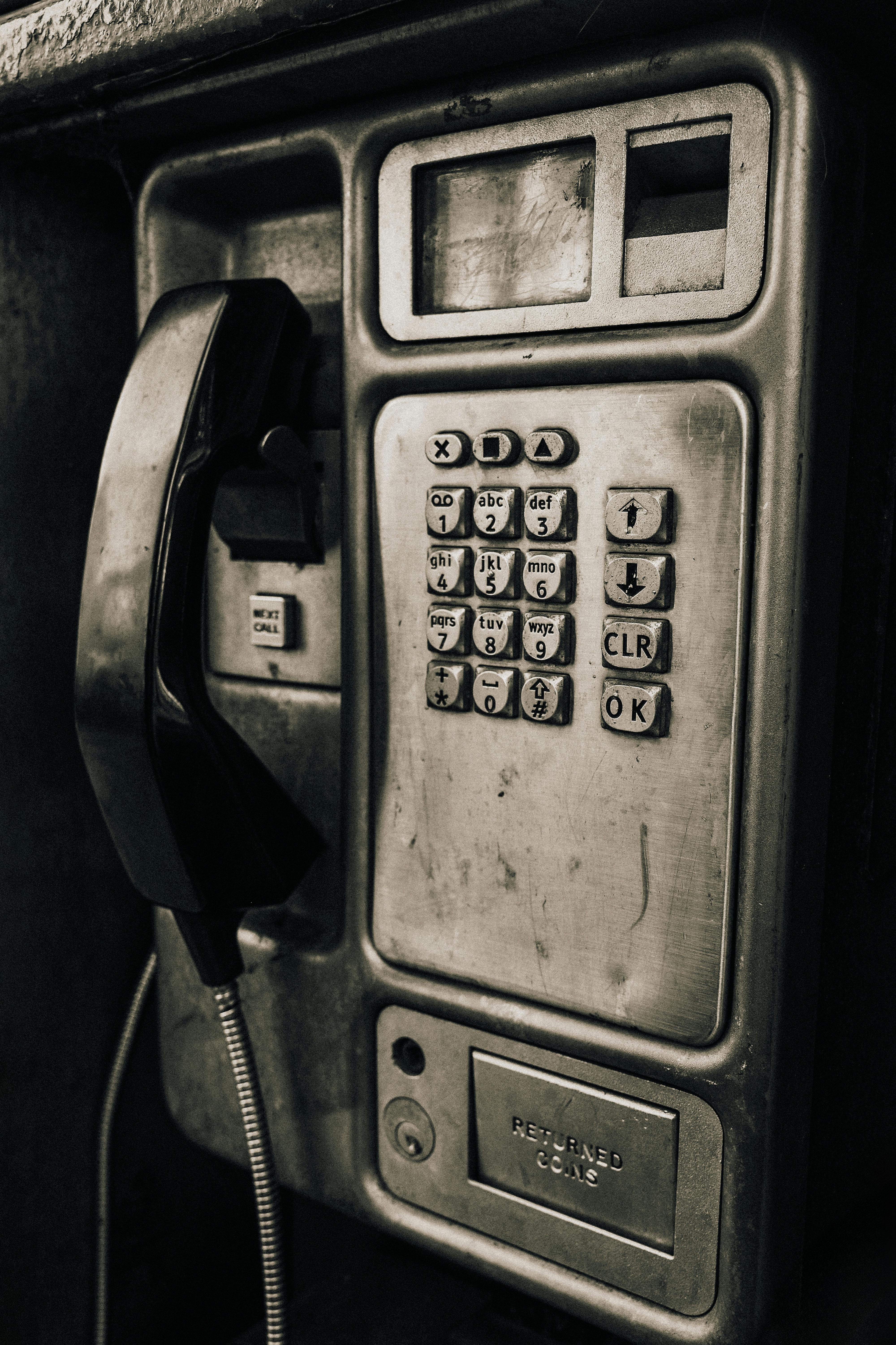 Kostenlos Eine Nahaufnahme eines altmodischen Münztelefons im Vintage-Stil, aufgenommen in Sepiatönen. Stock-Foto