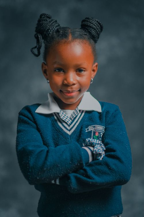 Free Portrait of a young schoolgirl wearing a blue uniform with crossed arms. Stock Photo