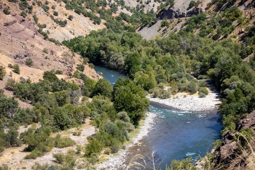 Free Beautiful river meandering through lush green valley in Tunceli, Türkiye under bright sunlight. Stock Photo