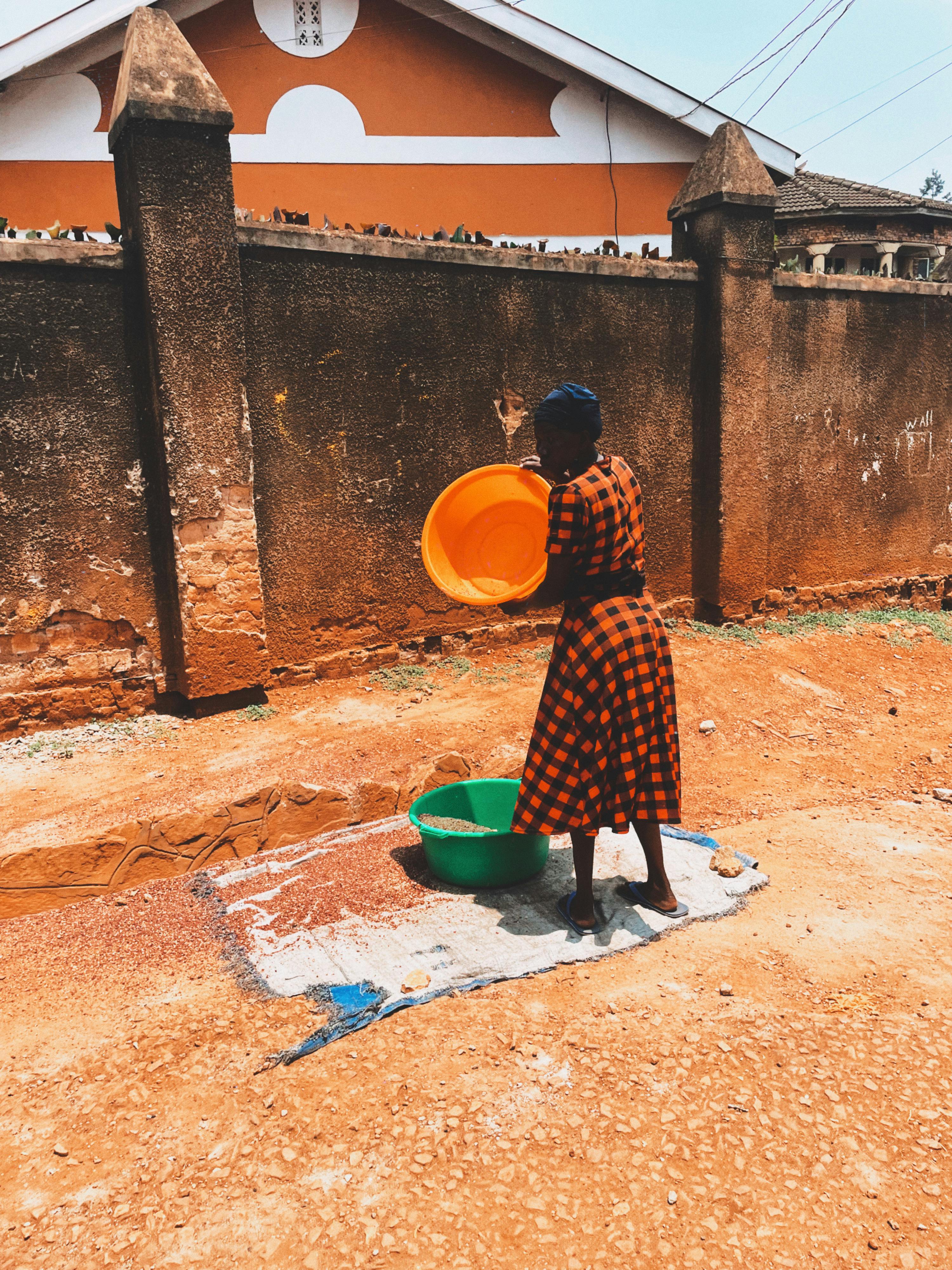 Free A woman washing clothes outdoors, embracing traditional life in rural Africa. Stock Photo