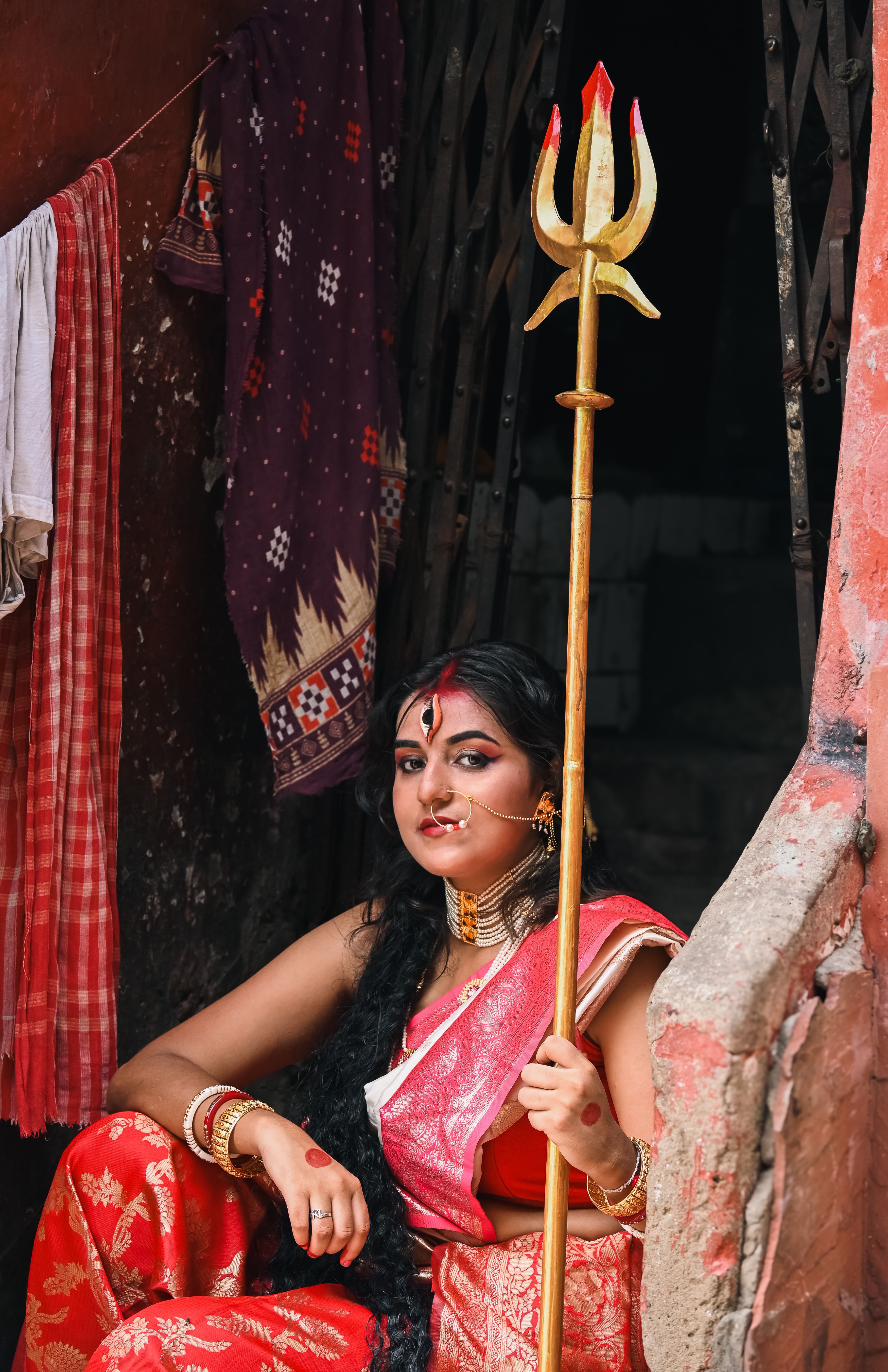 Portrait of a woman in traditional Bengali attire holding a trident, Kolkata.