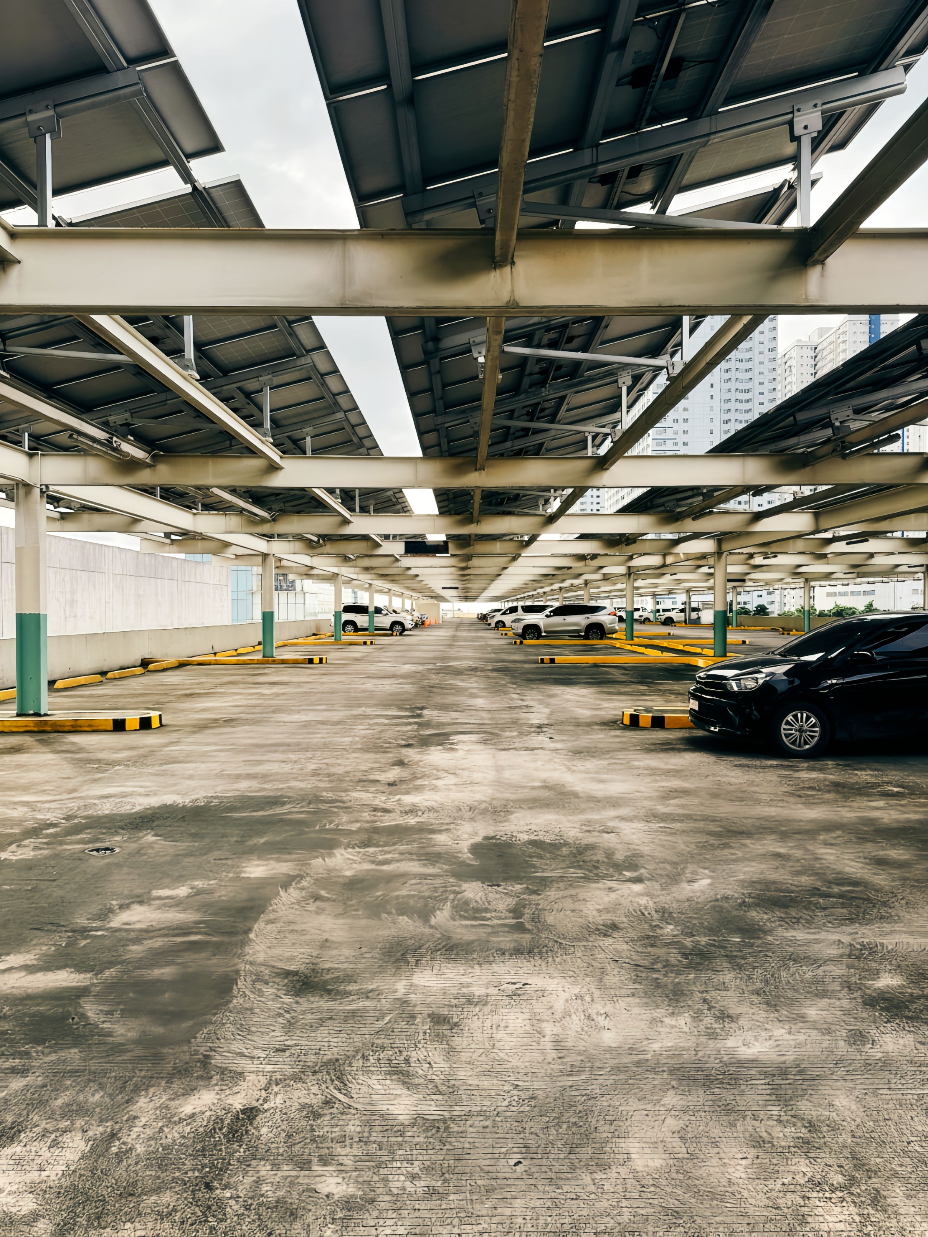 Parking couvert par des ombrières solaires avec véhicules garés en dessous