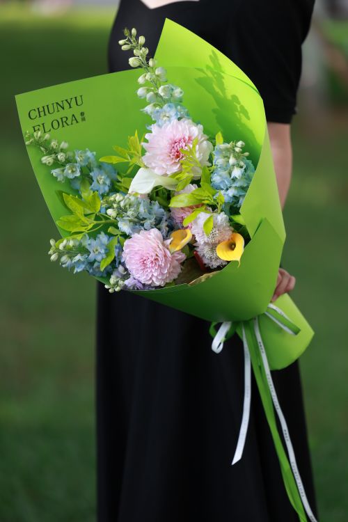 Free Vibrant bouquet of flowers held by a woman in a black dress, outdoors. Stock Photo