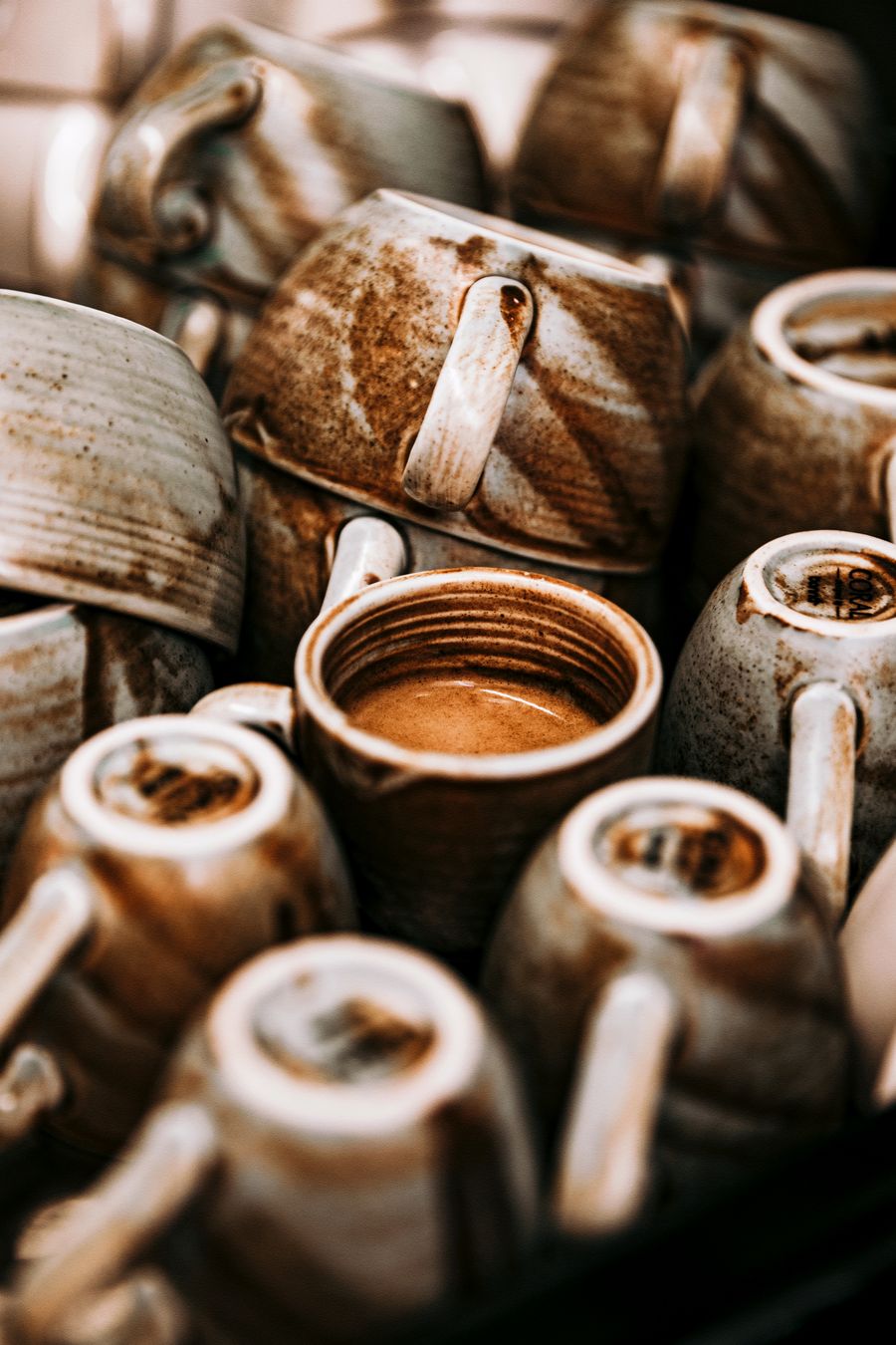 Stack of handcrafted ceramic mugs with earthy tones — photo by Masud Allahverdizade on Pexels
