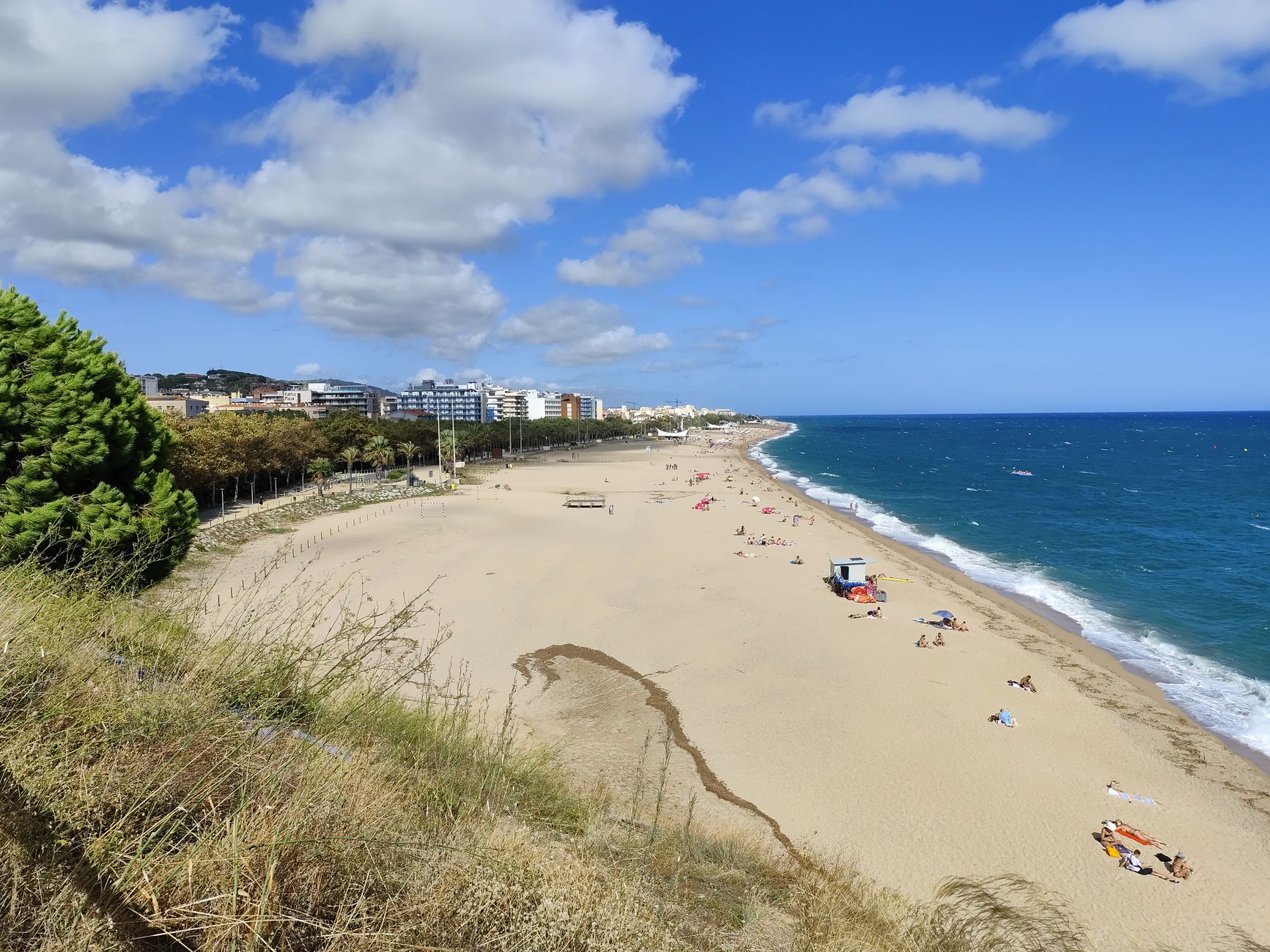 A sunny day at Calella beach in Catalonia, Spain, showcasing a beautiful coastal landscape.