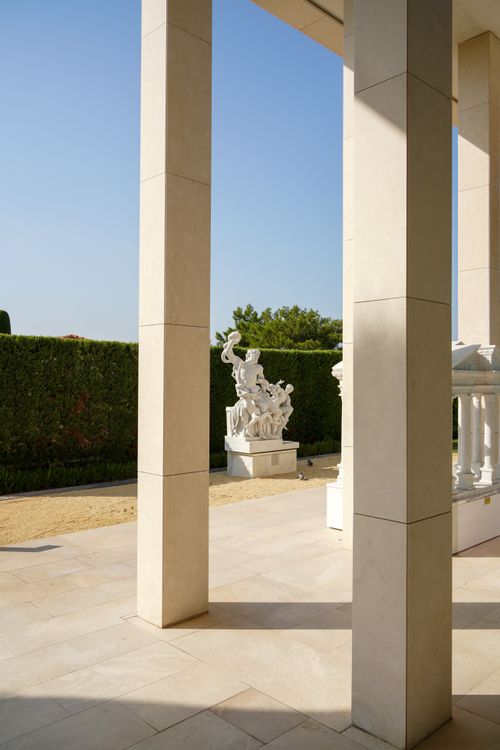 Free Elegant marble columns and classical sculpture in a sunny garden. Stock Photo