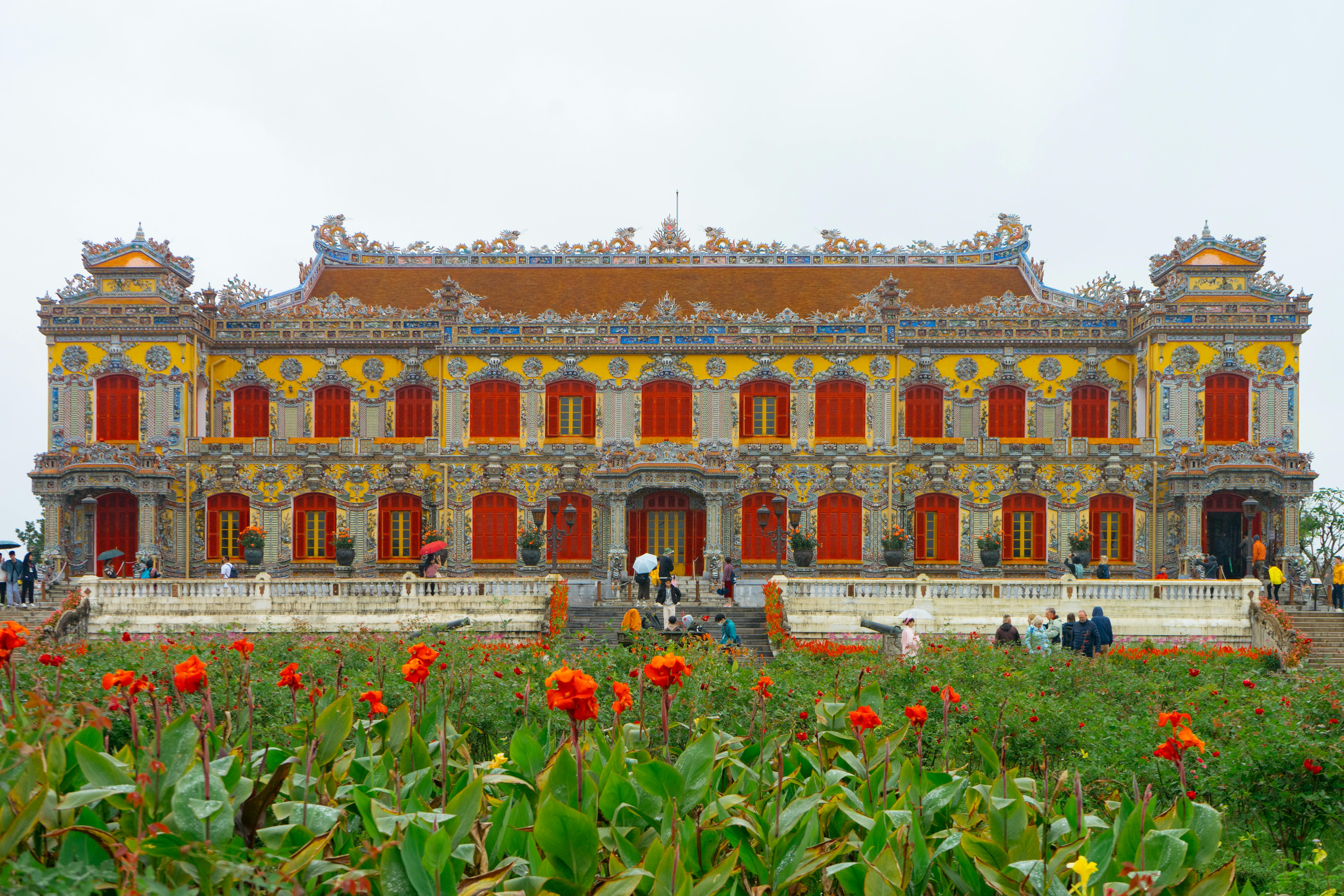 Vibrant entrance to the Imperial City in Hue, Vietnam, with colorful blooms in the foreground.