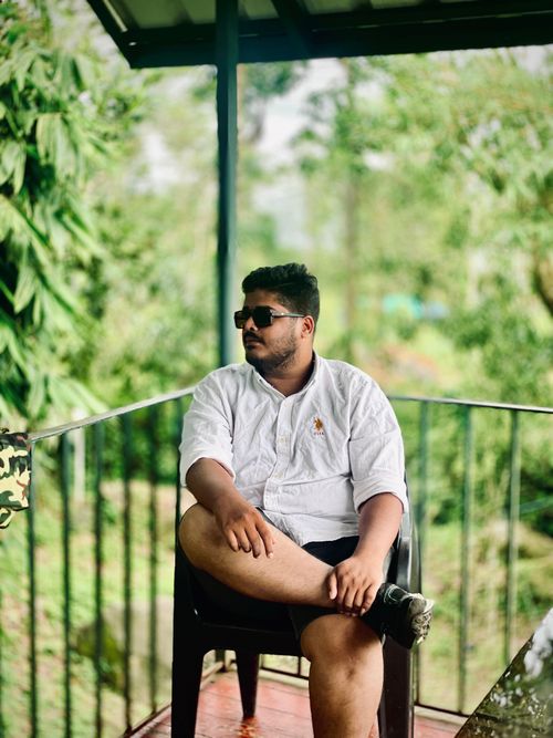 Free Casually dressed man sitting outdoors, enjoying the serene view. Stock Photo