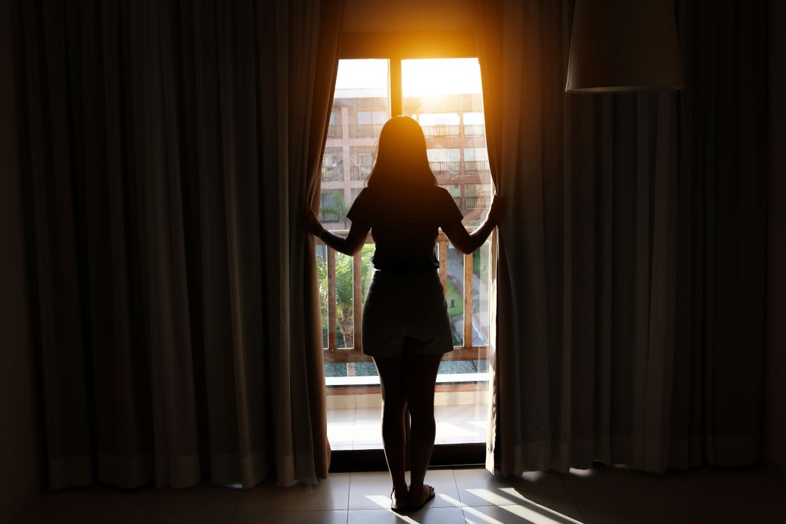 A Woman Standing Beside the Glass Window · Free Stock Photo