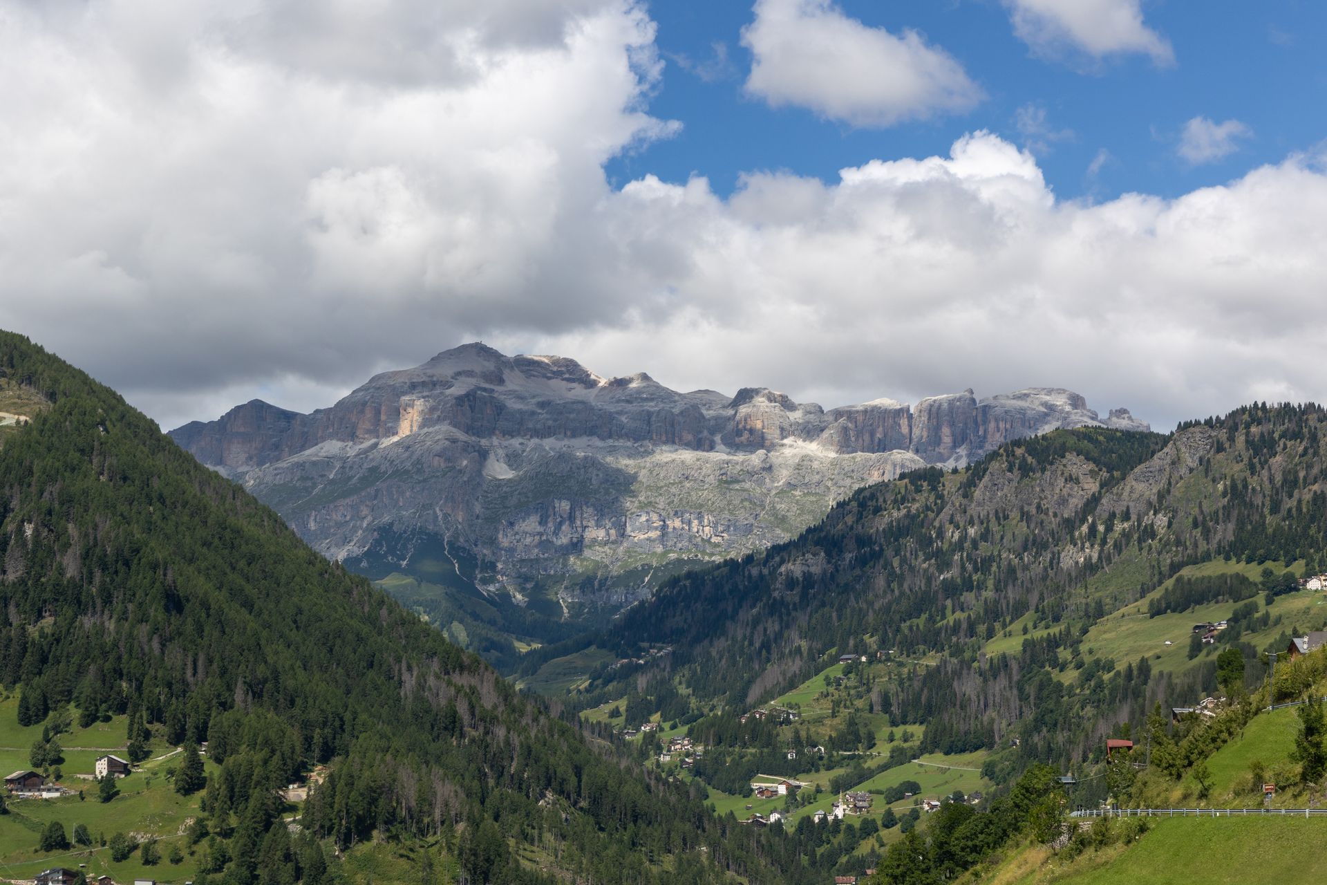 Mountainous landscape with clouds over green hills in a serene valley setting