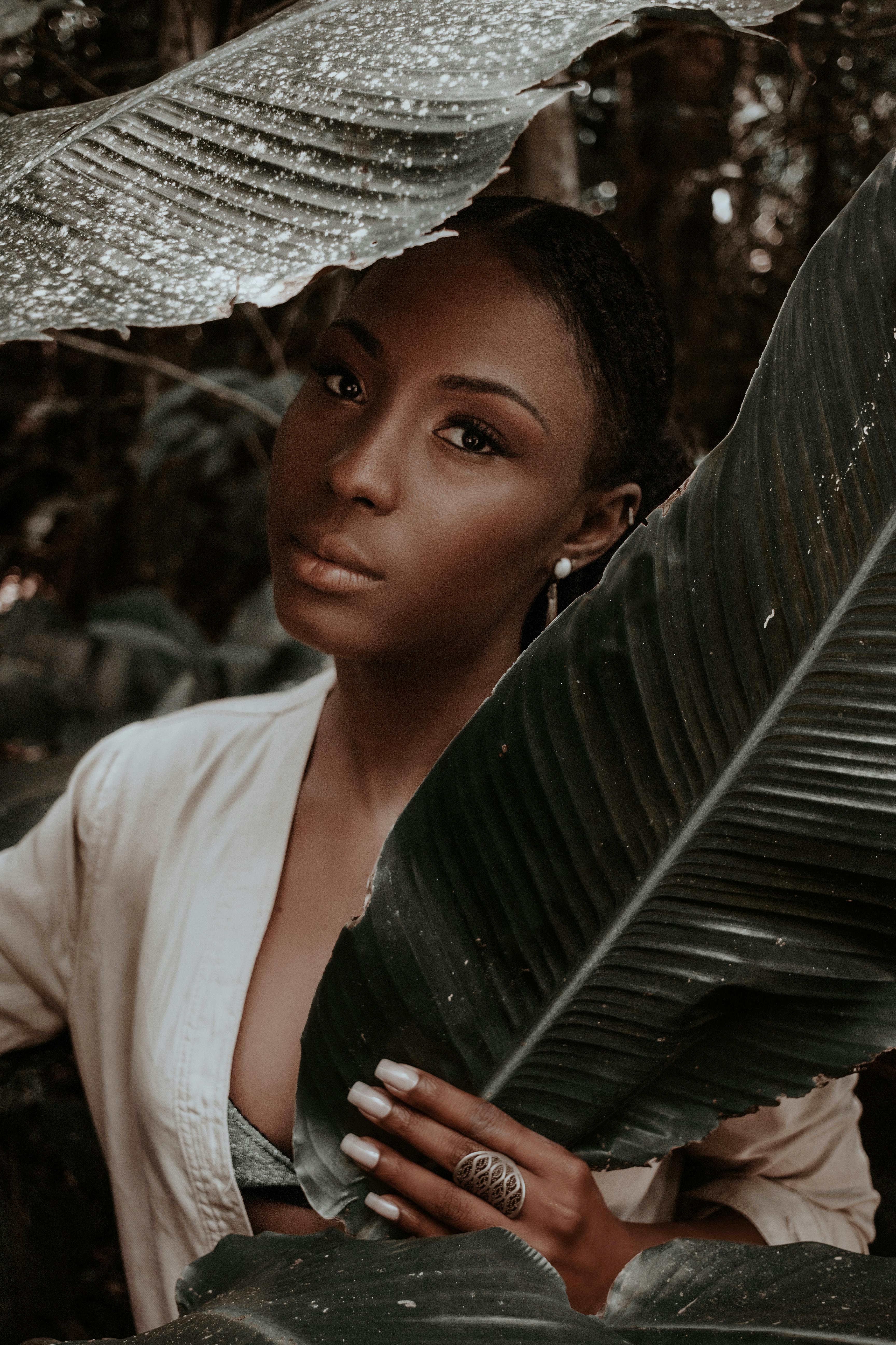 一幅被热带树叶环绕的女性肖像引人注目，展现了自然之美与独特风格