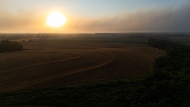 A stunning sunset capturing the tranquil beauty of agricultural fields and natural scenery.
