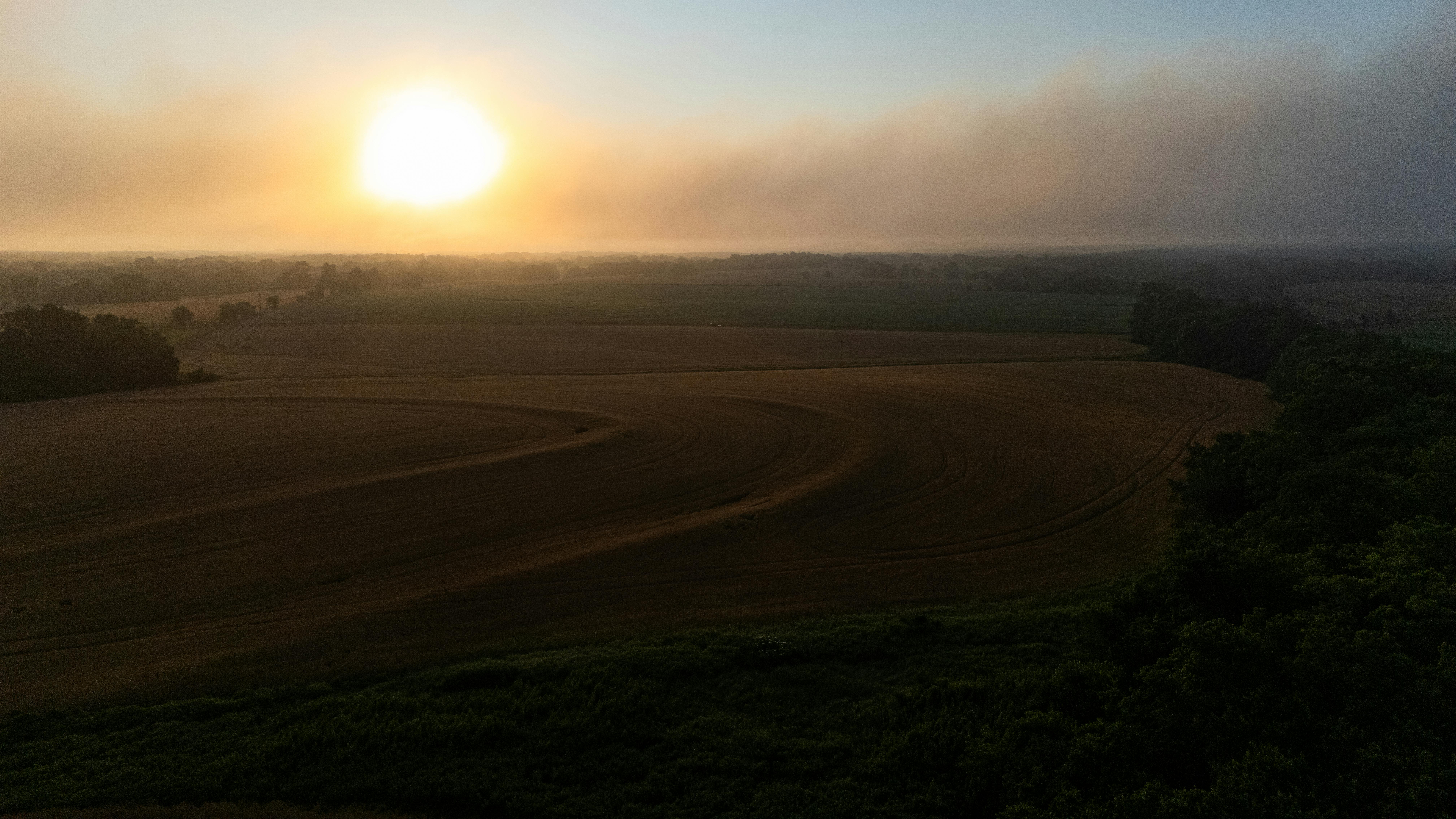 De franc Una posta de sol impressionant que captura la bellesa tranquil·la dels camps agrícoles i el paisatge natural. Foto d'estoc
