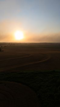 A breathtaking view of sunset over expansive farmland fields, capturing the beauty of nature.