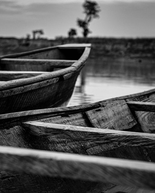 Free Black and white photo of rustic wooden boats on a serene lake, exuding tranquility. Stock Photo