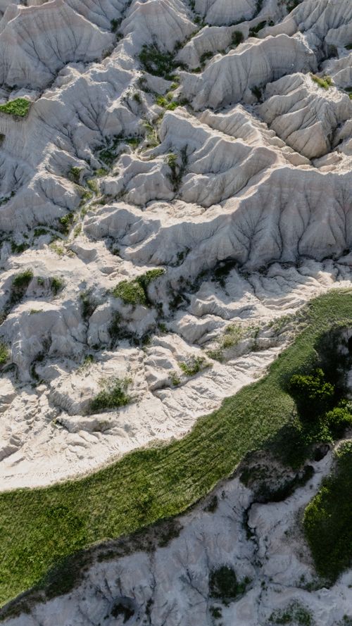 Free Aerial perspective of the rugged and textured badlands landscape in South Dakota, vibrant at golden hour. Stock Photo