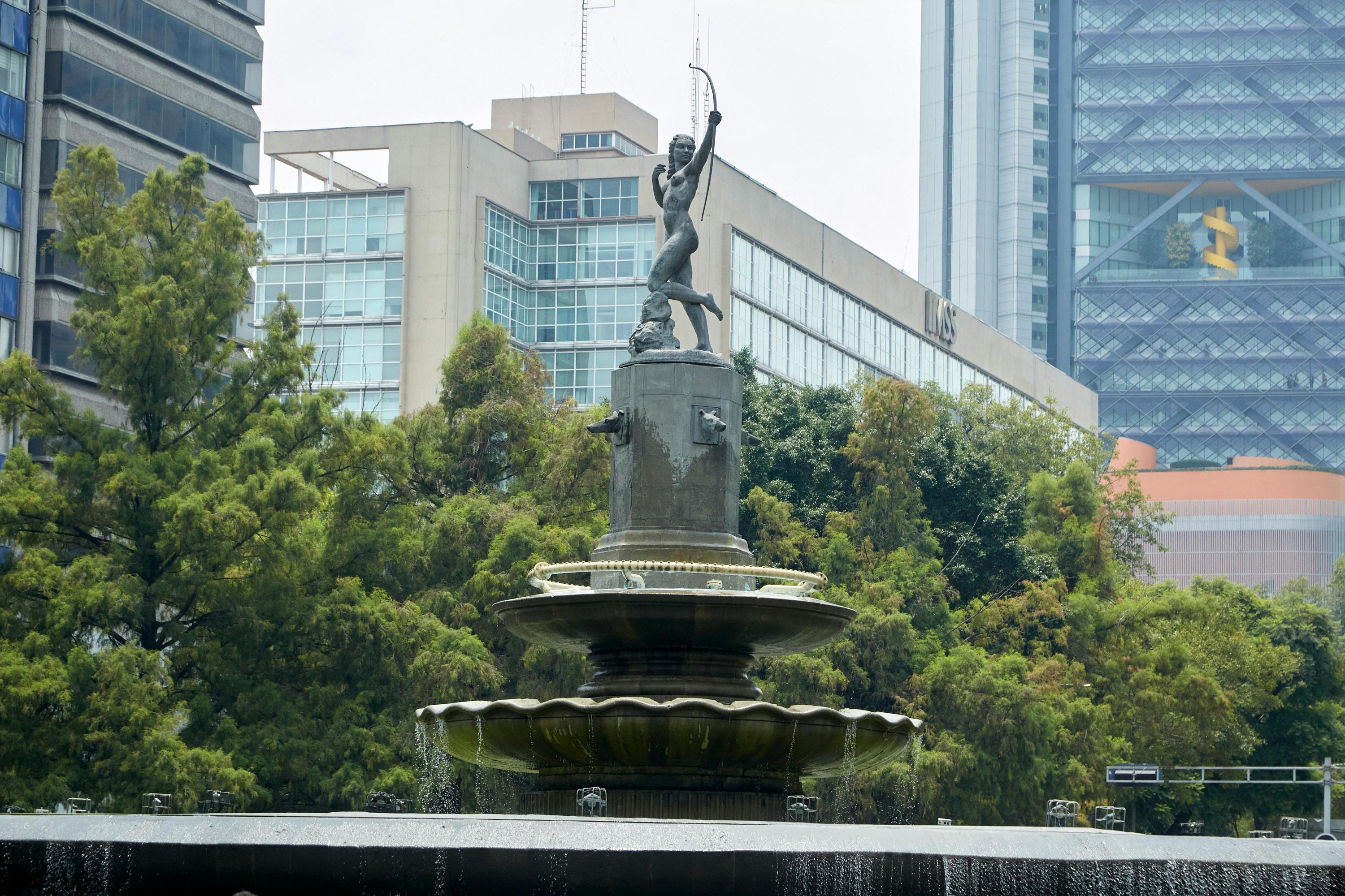 Diana the Huntress Fountain with skyscrapers in Mexico City, daytime view.