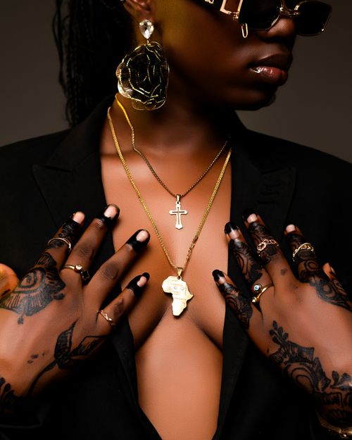 Free An elegant portrait showcasing gold jewelry, henna designs, and fashionable attire. Stock Photo