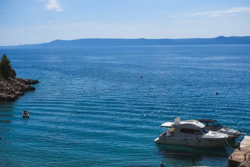 Free Serene seascape featuring white boats on clear blue water under a sunny sky, ideal for travel inspiration. Stock Photo