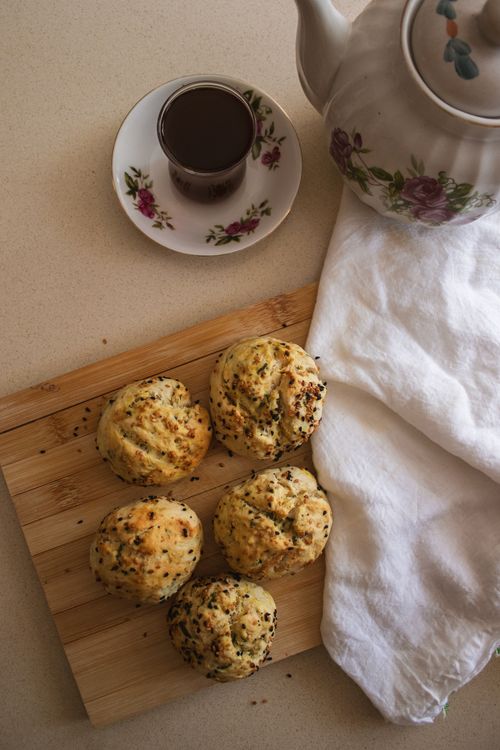 Free Top view of freshly baked scones with tea set on a wooden board, creating a warm and inviting atmosphere. Stock Photo
