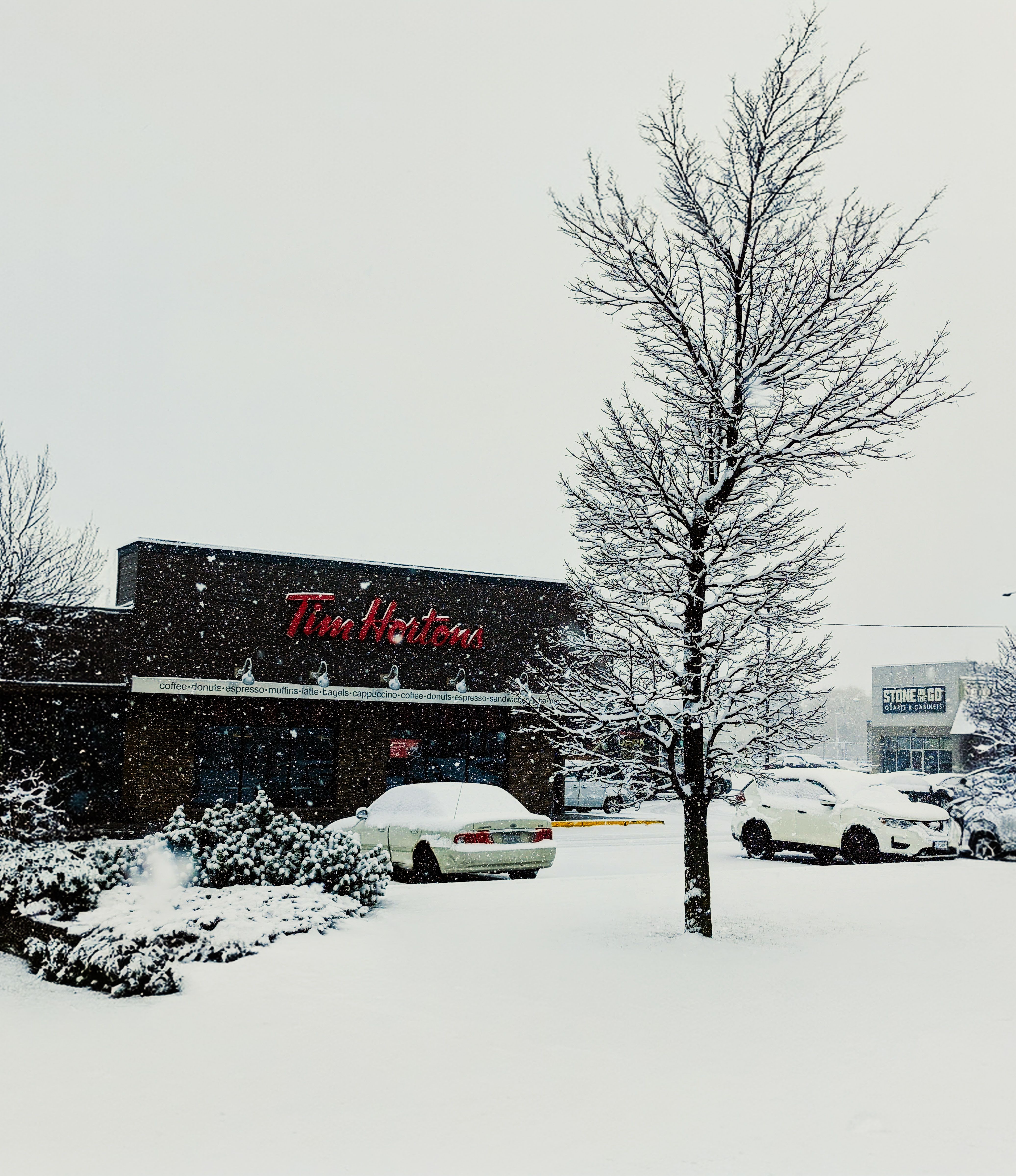 Tim Hortons restaurant surrounded by snow during a winter day, showcasing a seasonal Canadian scene.