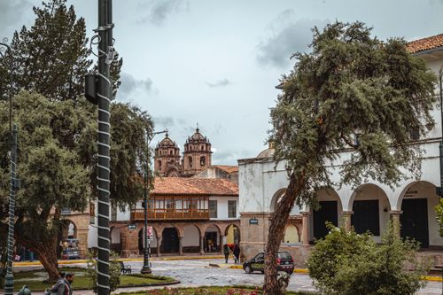 Free Charming view of a historical square in Cusco, Peru with colonial architecture and lush greenery. Stock Photo