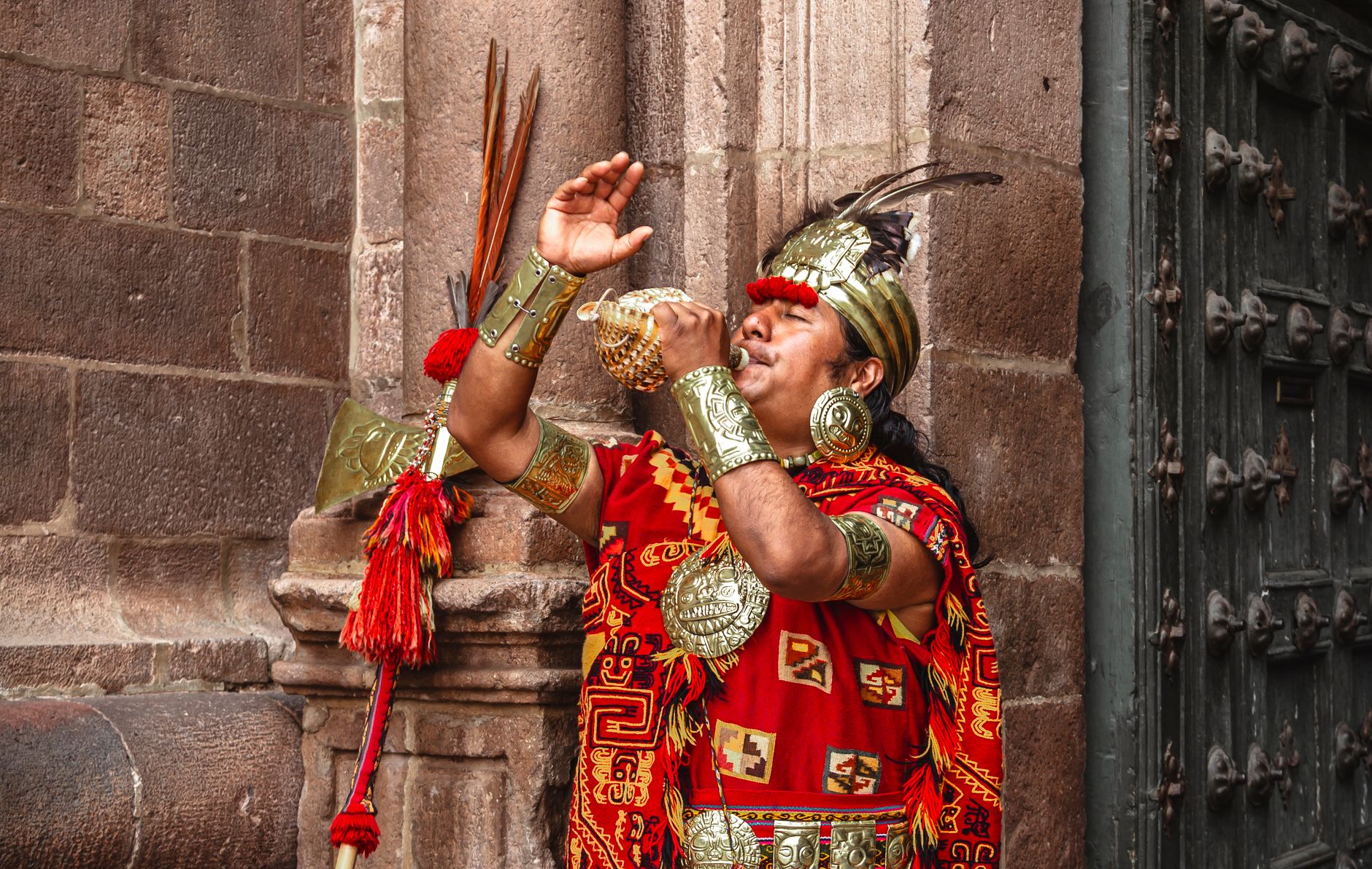 Man in Inca attire performing a ritual in Cusco, Perú