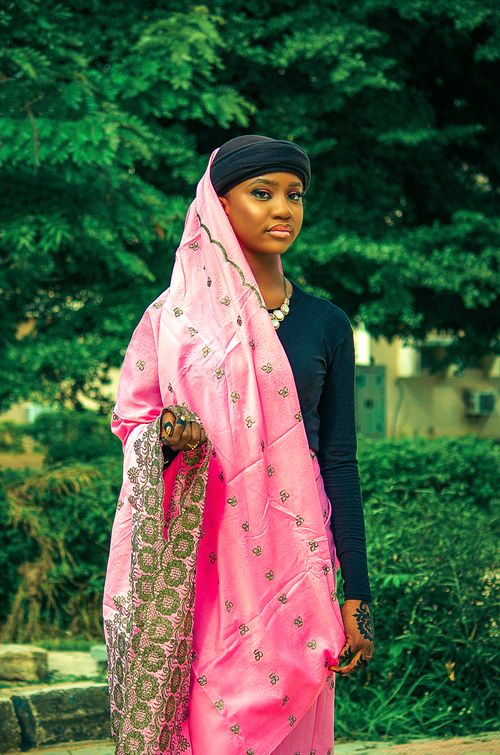 Free A young woman in colorful traditional attire posing outdoors amidst greenery. Stock Photo