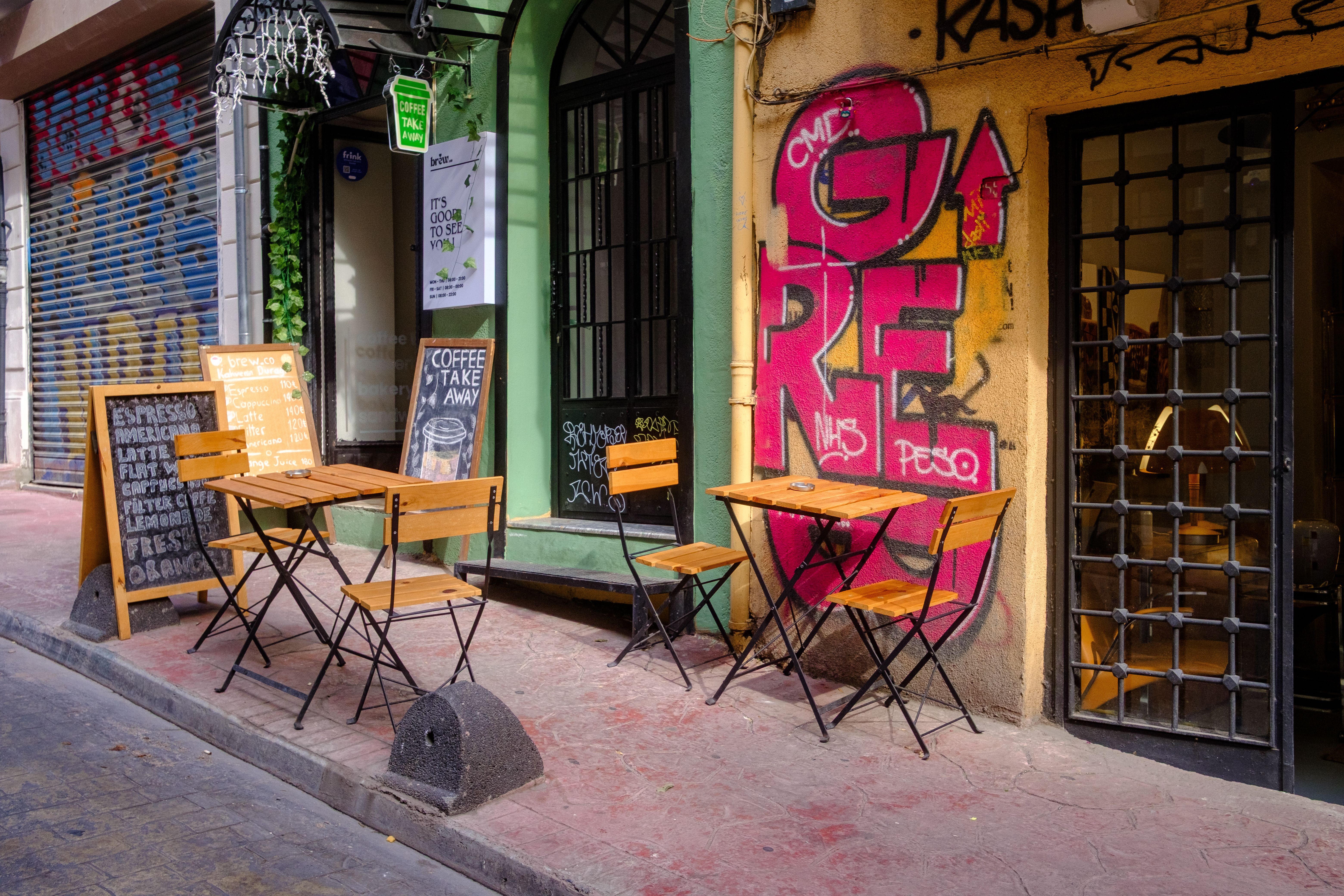 Outdoor café with vibrant graffiti creates an urban street vibe.