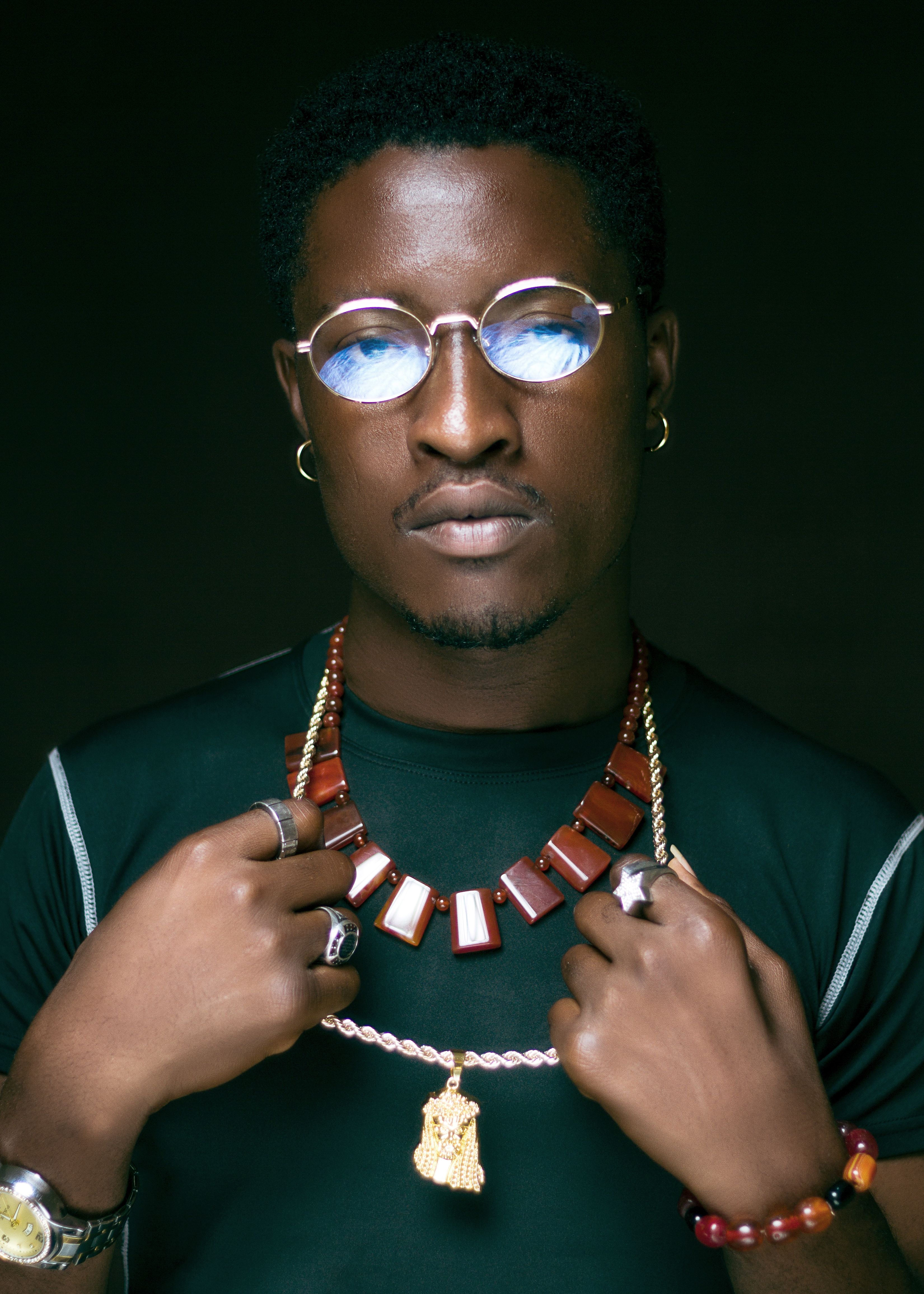 Stylish man wearing unique glasses and bold jewelry. Captivating portrait.