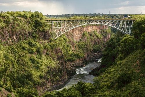 Free Victoria Falls Bridge gracefully arcs over the lush Batoka Gorge in Zimbabwe, showcasing stunning natural beauty. Stock Photo