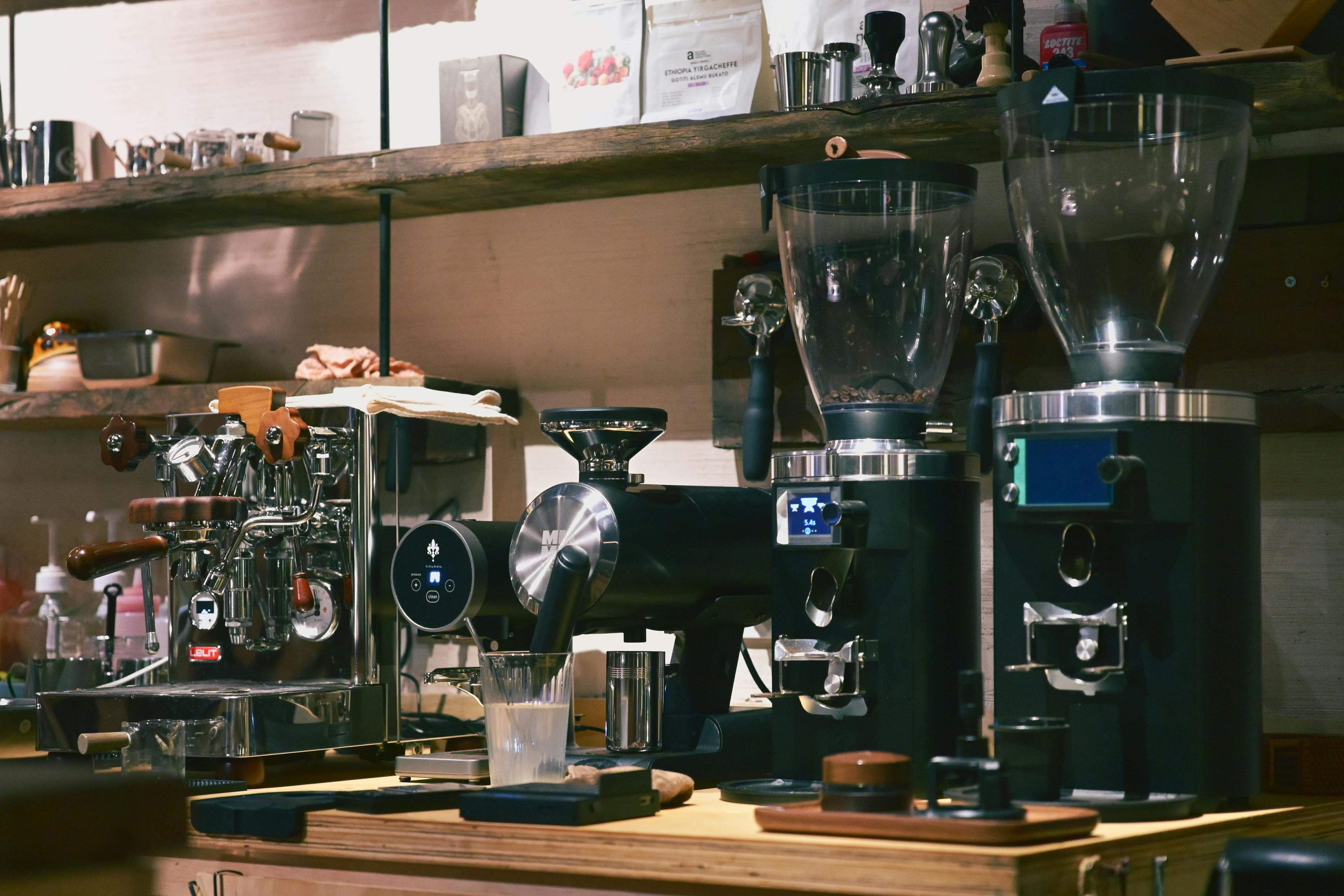 High-end coffee machines and grinders in a cozy café setting.