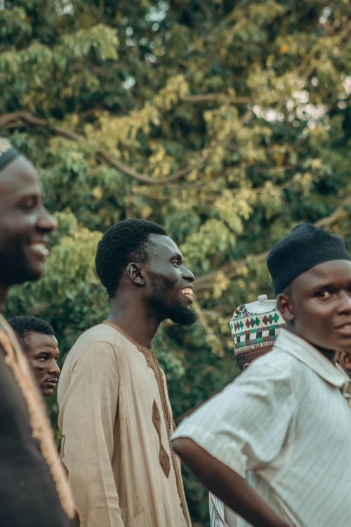 Free A group of men in traditional attire enjoying an outdoor gathering amidst greenery. Stock Photo