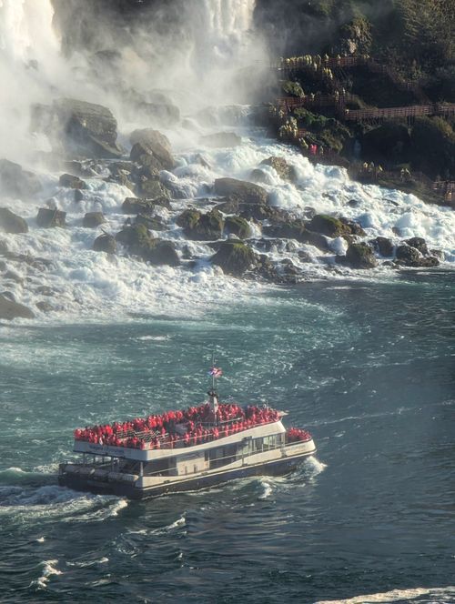 Free Tourist boat full of visitors at Niagara Falls, surrounded by mist and rushing water. Stock Photo