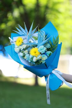 Colorful blue and yellow flower bouquet in bright sunlight, perfect for celebrations.