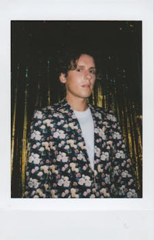 时尚的年轻人穿着花卉夹克，搭配金色褶皱，展现了现代时尚感